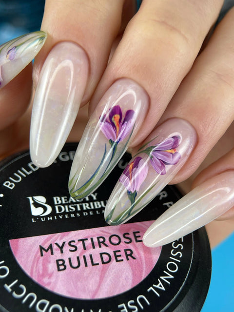 Pose amande avec décor floral et reflets nacrés, pot Mystirose Builder Beauty Distribution visible. Création Nail Champion. Le décor et les reflets nécessitent des produits complémentaires.