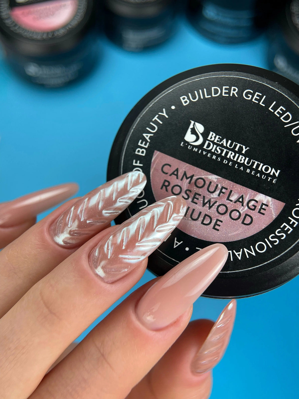 Pose amande nude avec gel Rosewood Nude Beauty Distribution et décor blanc en relief, création Nail Champion.