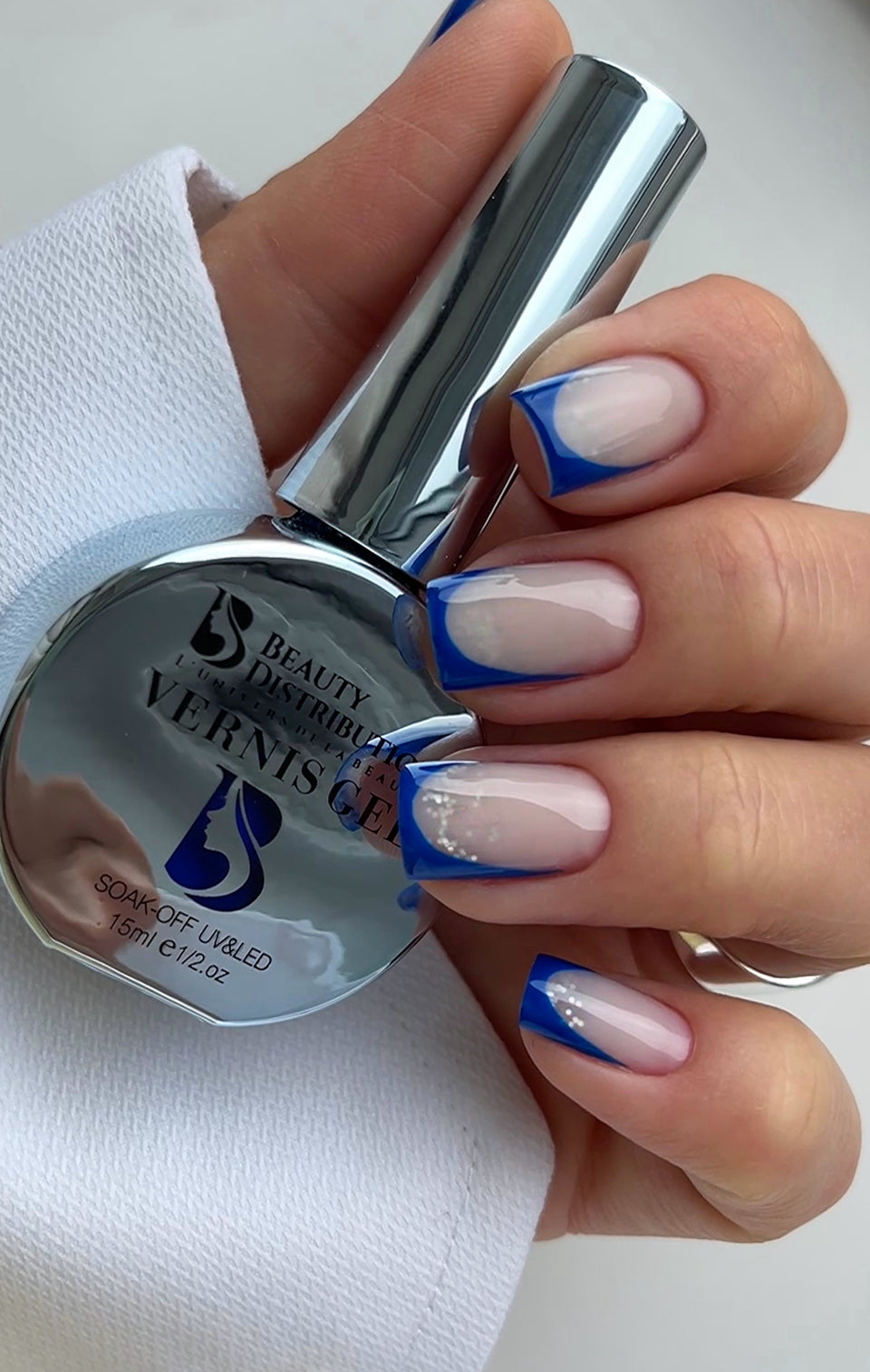 French manucure bleue et flacon de vernis gel UV/LED Beauty Distribution 15 ml.