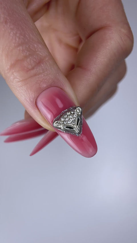 Fixation d’un bijou d’ongle avec Glue Gel+ 30 g Beauty Distribution par Nail Champion. Le tube est visible ; la couleur, le bijou et le top coat sont distincts.