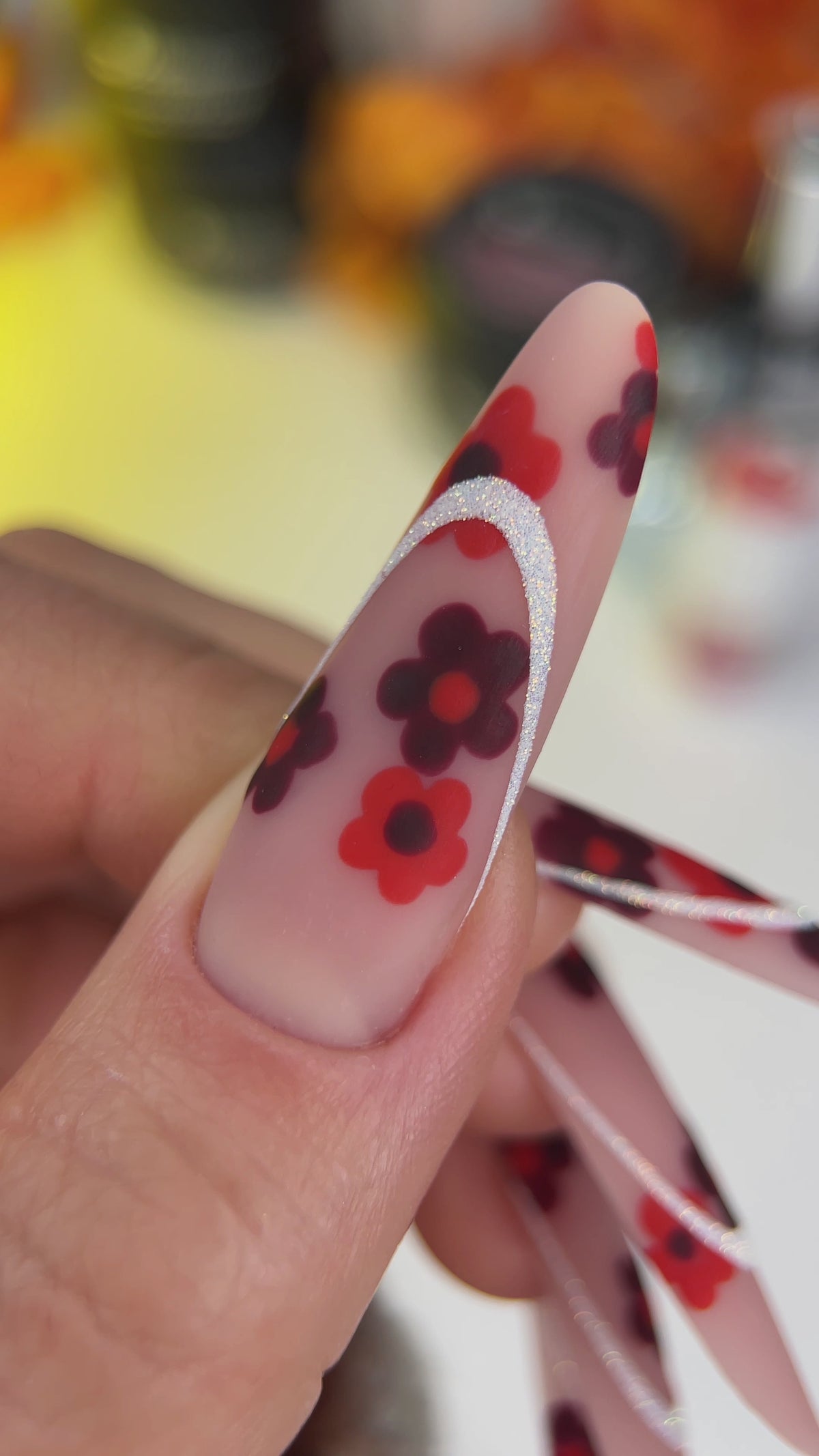 Manucure longue nude décorée de fleurs rouges